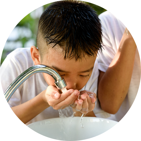 Kind trinkt Wasser vom Hahnen